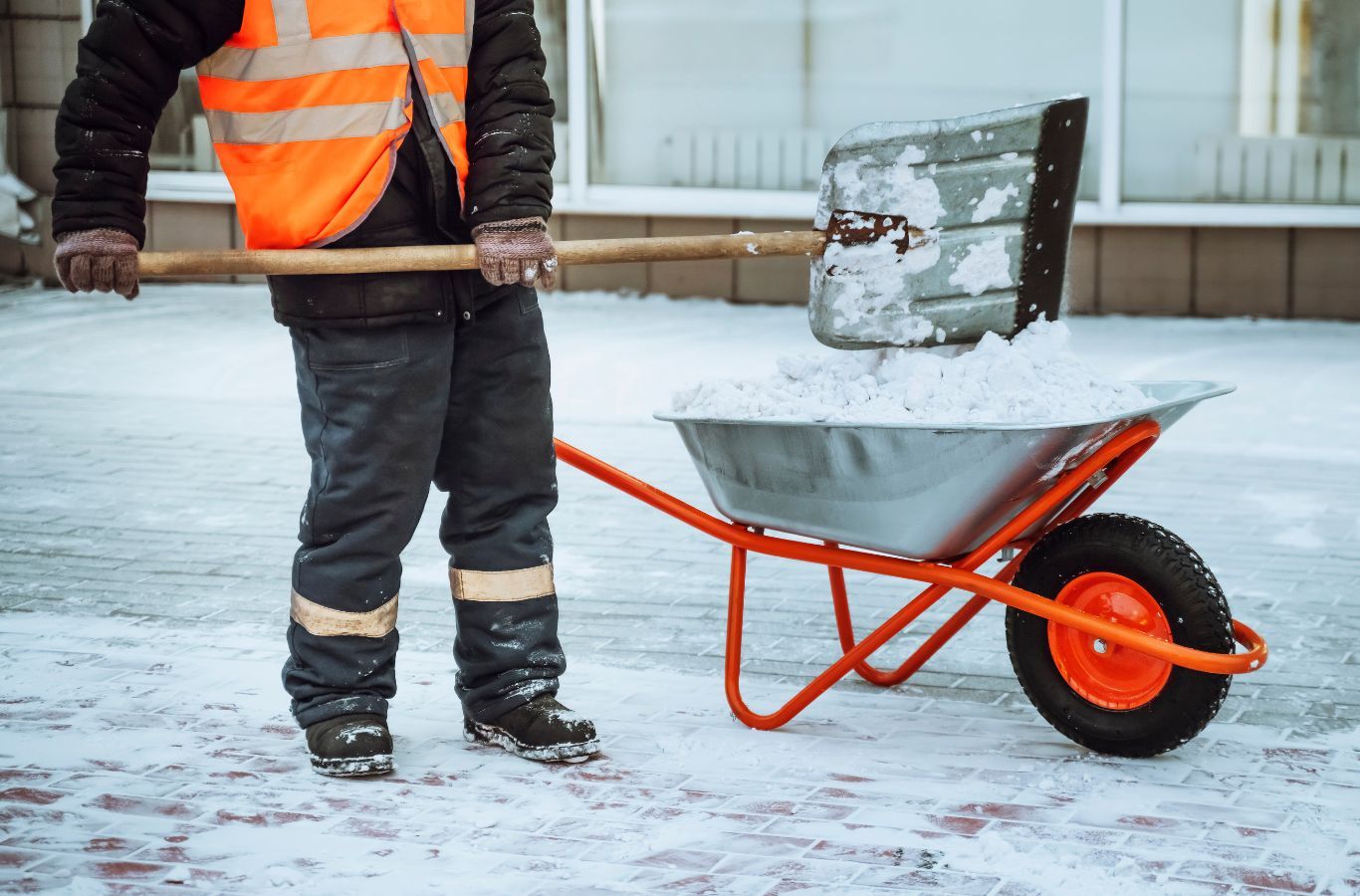 A BE&P Services employee clearing snow from a driveway in Discovery Ridge, AB, ensuring safe and accessible pathways.